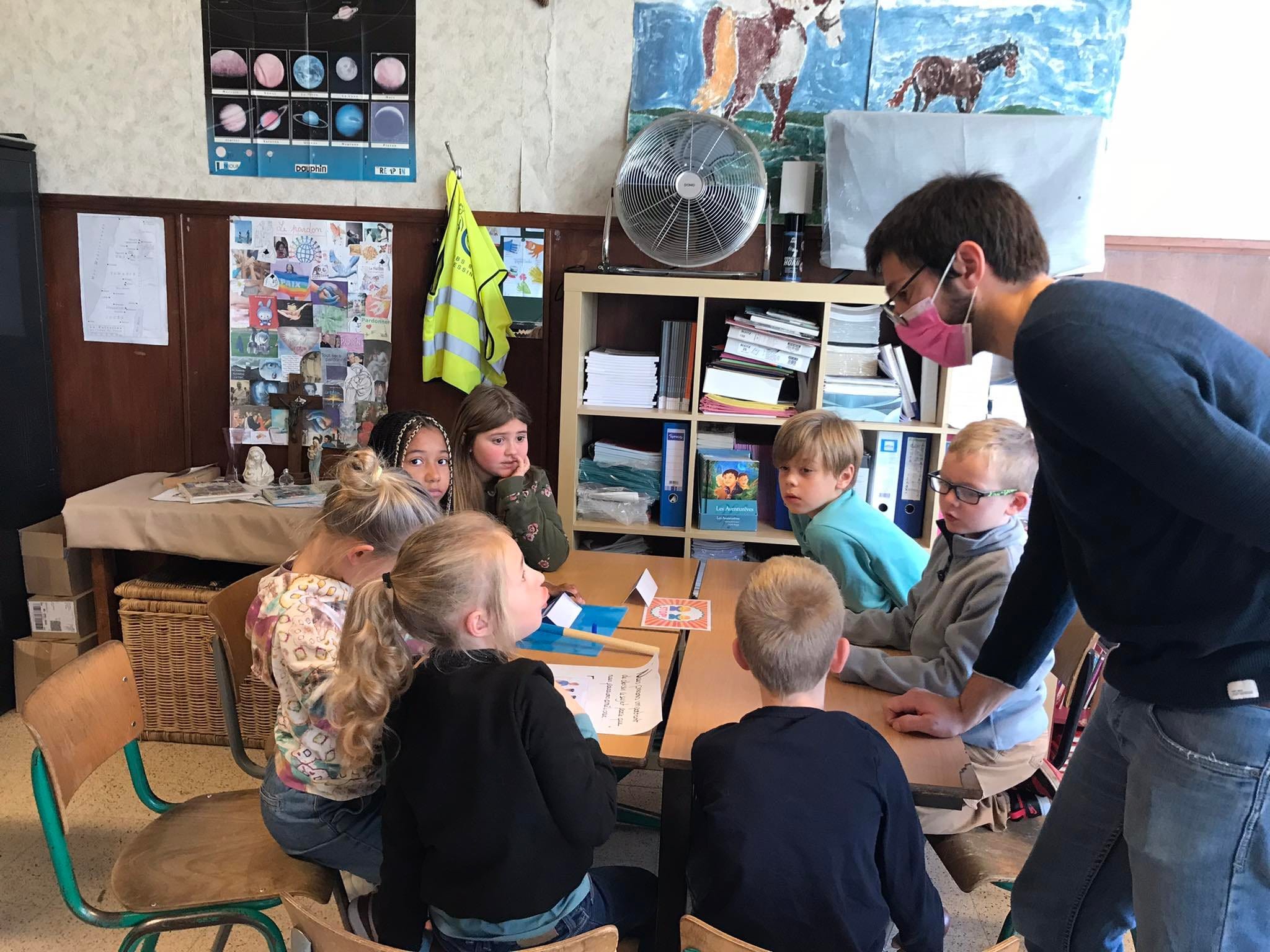 Enfants réunis autour d'une table pour parler des thèmes de la société
