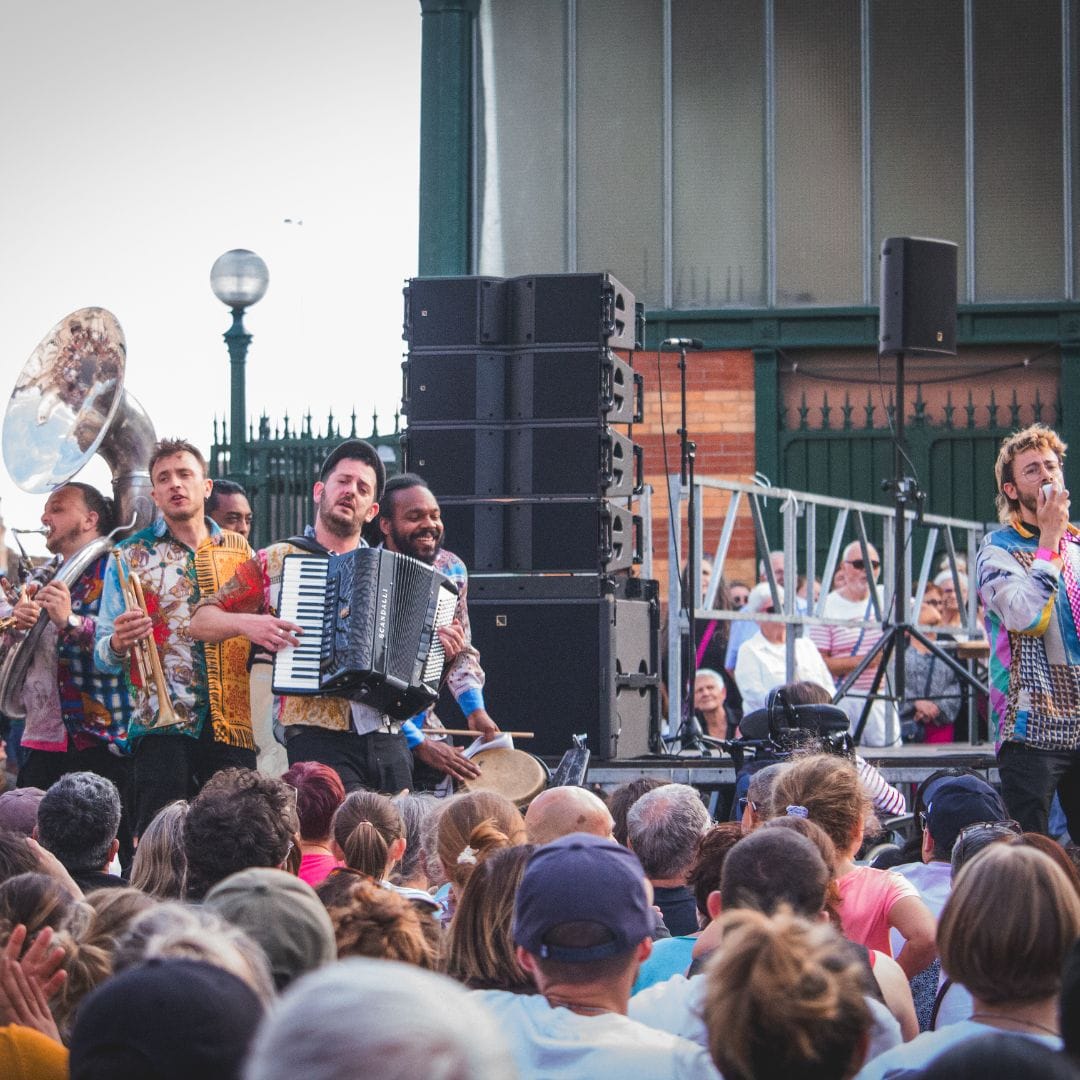 La fanfare fait de la musique et chante.