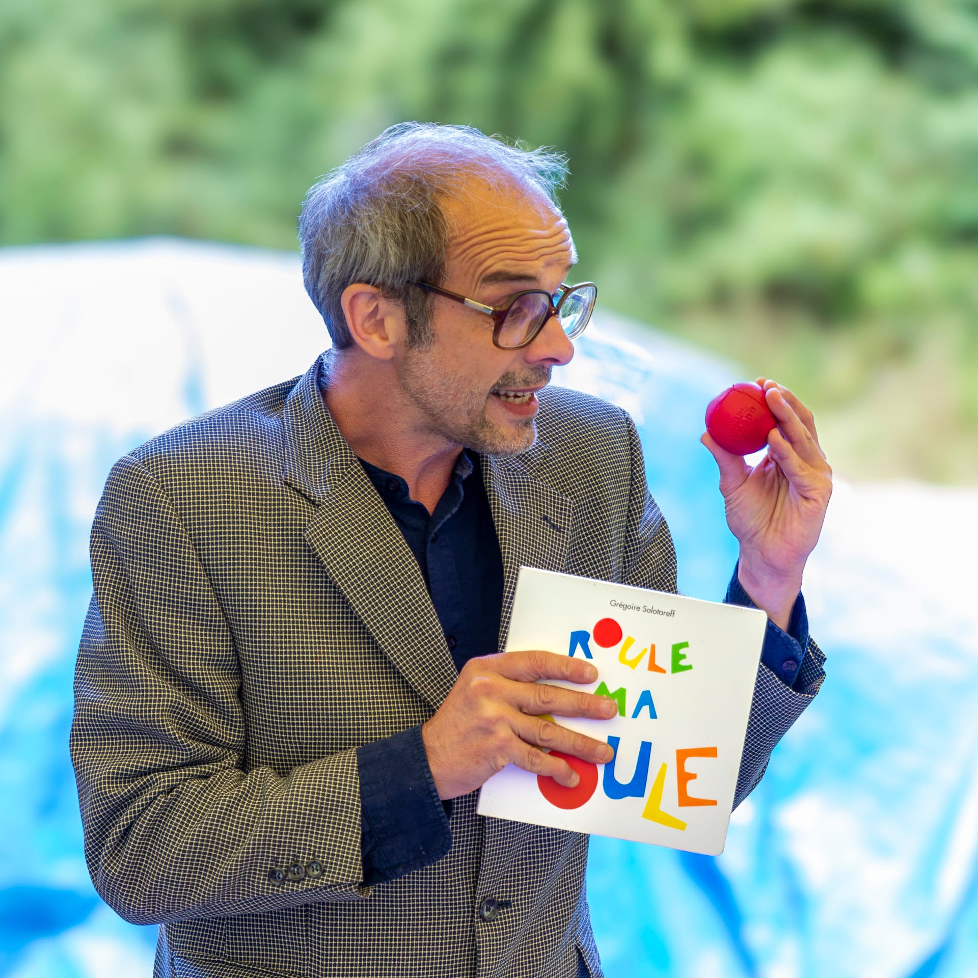 Le comédien montre une boule rouge au public