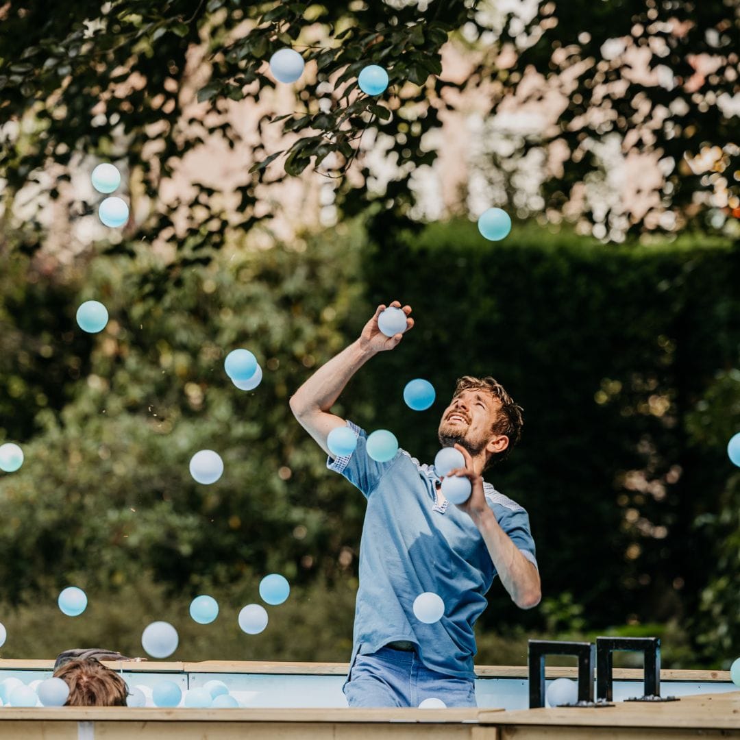 L'artiste lance des boules bleues dans une piscine.