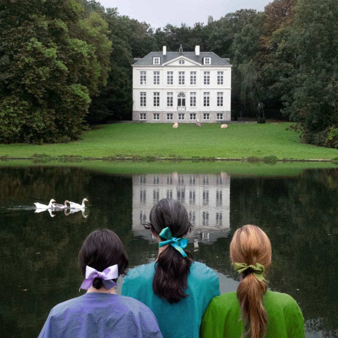 Les trois comédiennes sont au bord d'un lac et regardent un château au loin.