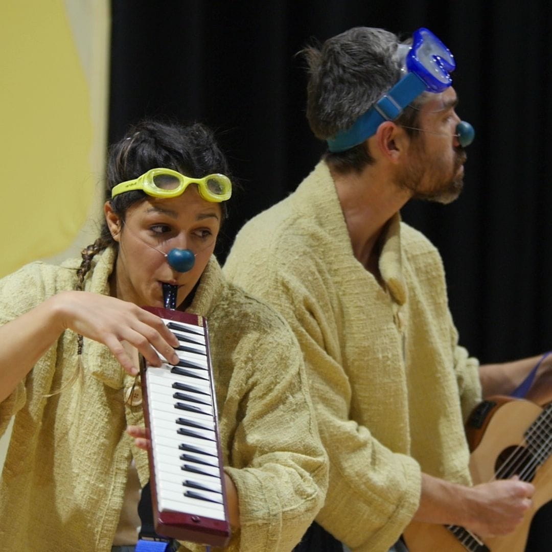 Un des clowns fait du piano et l'autre de la guitare.