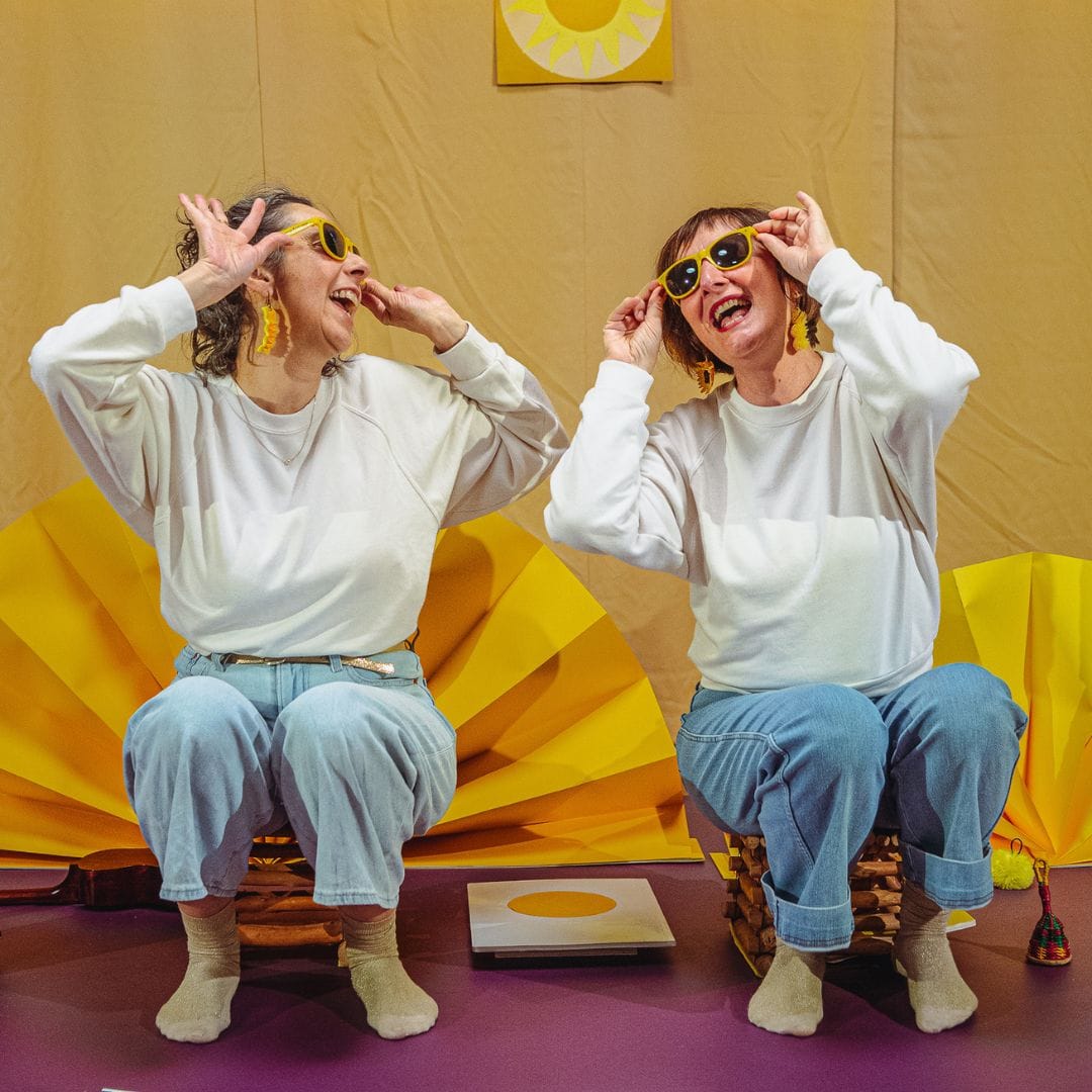 Deux femmes portent des lunettes jaunes en souriant.
