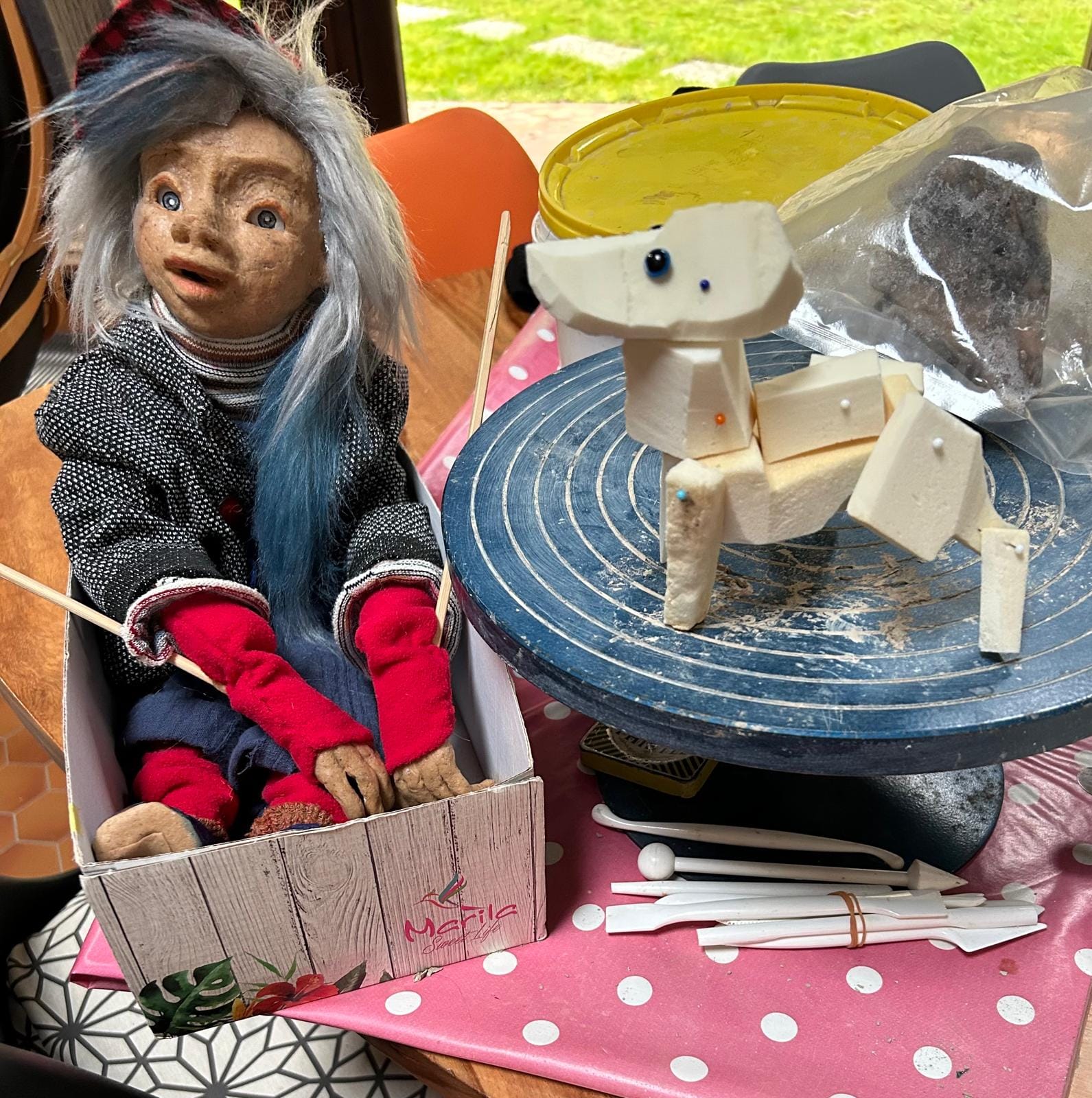 Une marionnette est dans une boîte en carton.